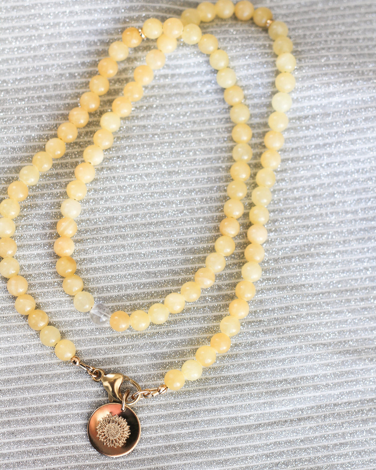 Close-up of round 6mm Honey Calcite gemstone beads in warm golden yellow tones.