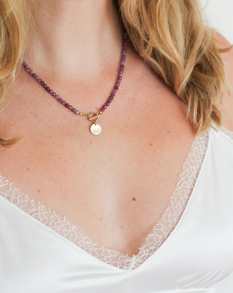ruby intention necklace with gold infinity charm