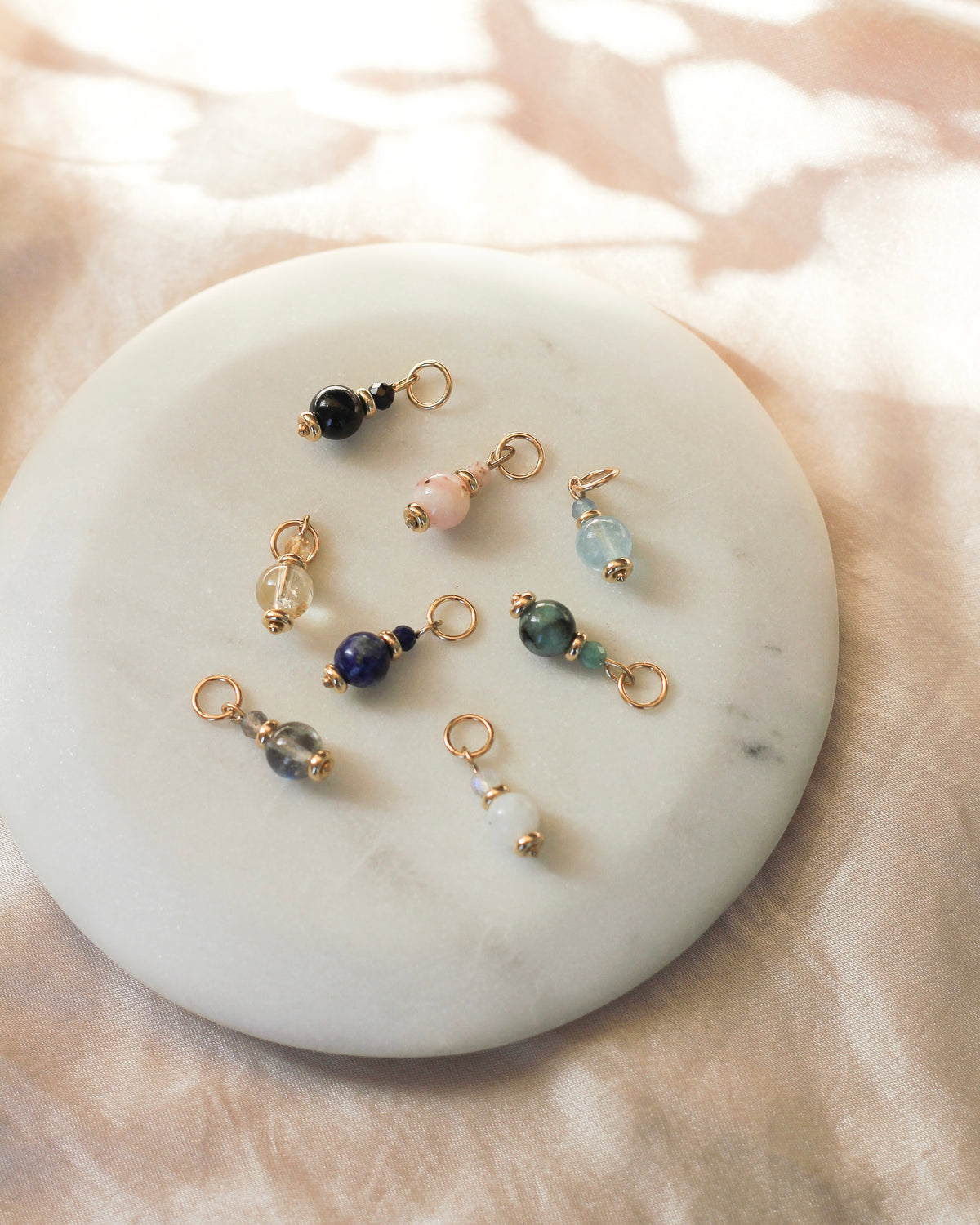 Gemstone charms layered with other meaningful charms