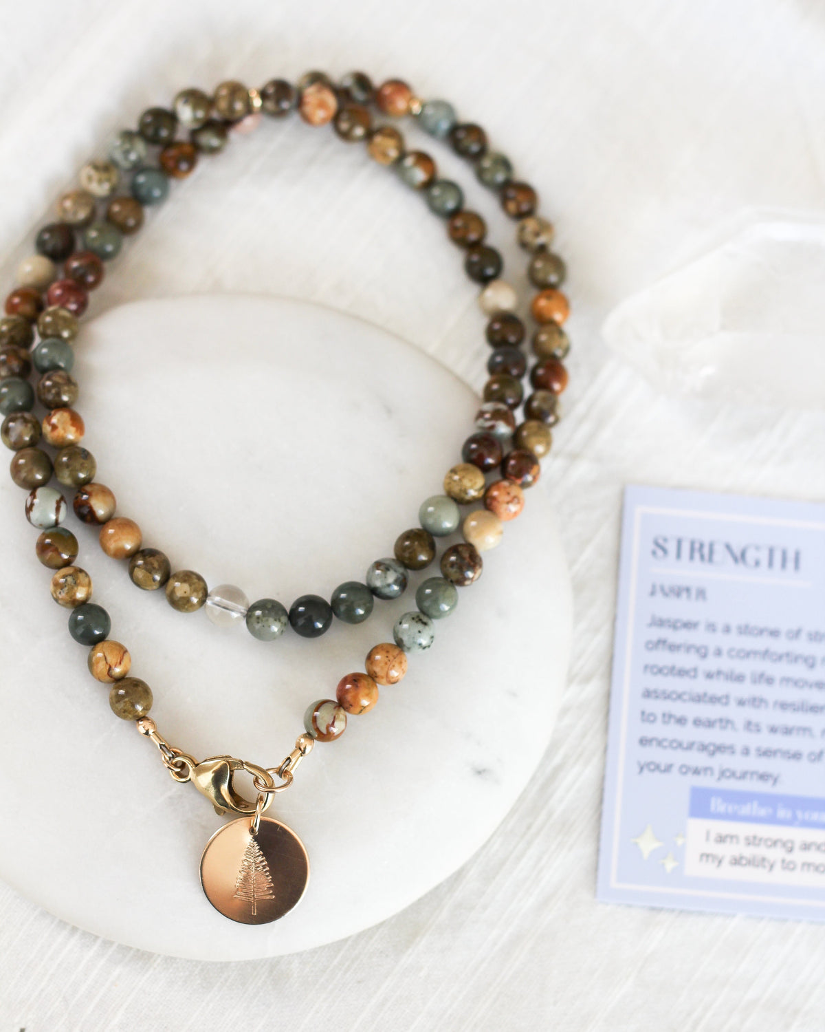 Close-up of smooth, round 6mm Jasper gemstone beads with natural earthy patterns.