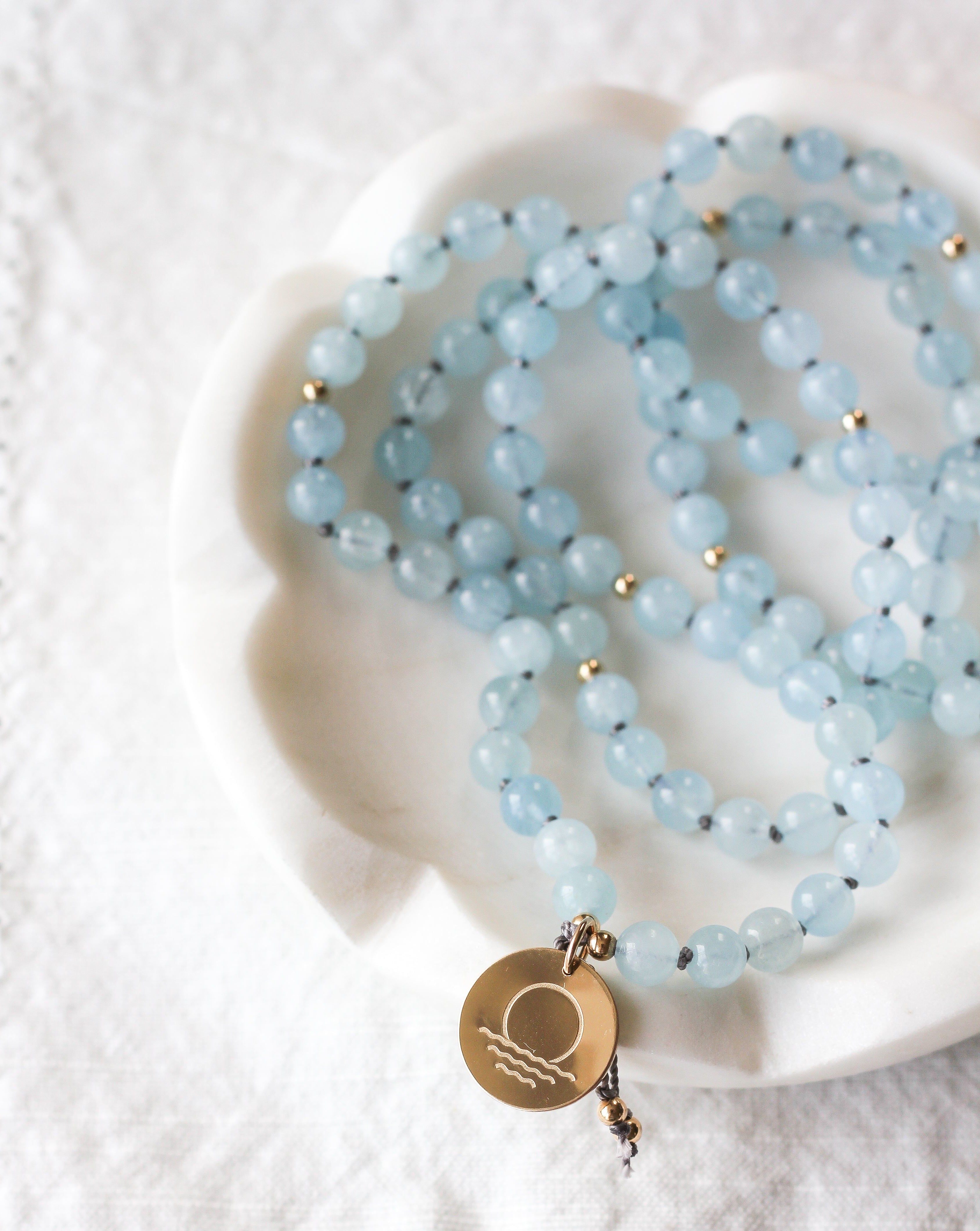 Tranquility Mala Pendant Necklace with Stamp Pendant on jewelry dish